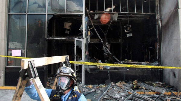 A fire marshal sets up equipment in front of a Royal Bank of Canada branch in Ottawa after it was firebombed on May 19, 2010. (Patrick Doyle / THE CANADIAN PRESS)