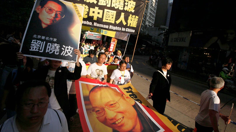 Pro-democracy protesters holding banners bearing photos of jailed Chinese dissident Liu Xiaobo march to the Chinese government liaison office in Hong Kong on Sunday, Dec. 5, 2010. (AP / Kin Cheung)