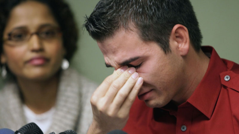 Adult film actor Derrick Burts, 24, who tested positive for HIV, reacts during a news conference, Wednesday, Dec. 8, 2010, in Los Angeles. Burts said he wished he had known more about the risks of contracting sexually transmitted diseases in the industry and is calling for mandatory condom use in porn films. At left is Dr. Shilpa Sayana.(AP Photo/Nick Ut)