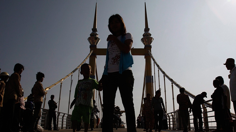 People walk on a bridge on which hundreds of people stampeded during a water festival last month in Phnom Penh, Cambodia, Wednesday, Dec. 8, 2010. (AP / Heng Sinith)
