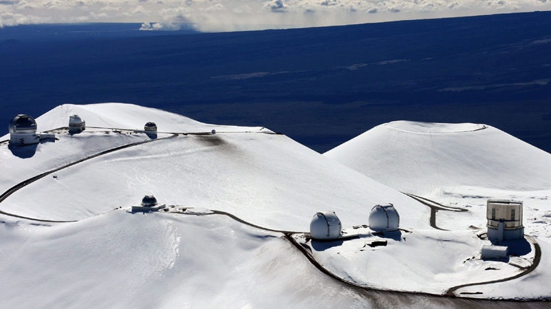In this Jan. 6, 2009 file photo, the astronomy observatories atop the snow capped mountain of Mauna Kea are seen near Hilo, Hawaii. (AP Photo/Tim Wright)