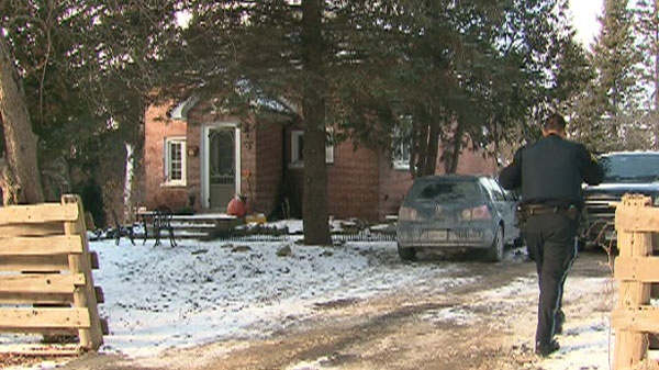 An OPP officer outside a Mono, Ont. home on Wednesday, Dec. 8, 2010 investigating an attack on a woman who lived there.