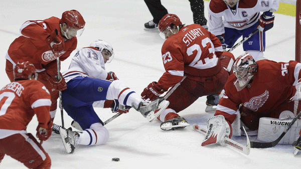 Montreal Canadiens left wing Mike Cammalleri (13) tries to control the puck in front of Detroit Red Wings goalie Jimmy Howard (35) during the third period of an NHL hockey game in Detroit, Friday, Dec. 10, 2010. Helping on the defense are winger Henrik Zetterberg, left, center Pavel Datsyuk of Russia, top left, and defenseman Brad Stuart (23). (AP Photo/Carlos Osorio)
