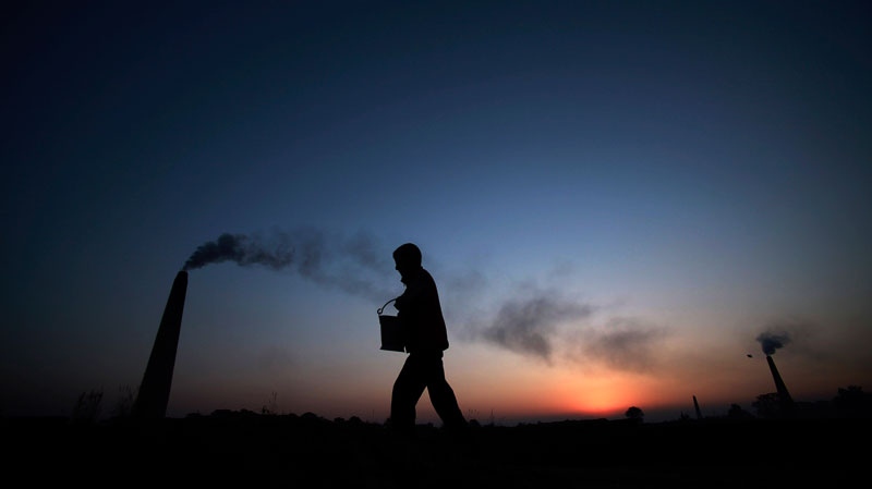 A boy walks past a brick factory on the outskirts of Jammu, India, Saturday, Dec. 11, 2010. After two decades of unbridled development, India is now the world's third-largest greenhouse gas emitter. (AP / Channi Anand)