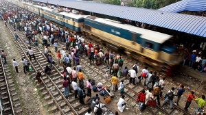 Bangladeshi passengers crowd a train station to travel home for Eid al-Adha, as an overloaded train arrives on the outskirts of Dhaka, Bangladesh, Saturday, Nov. 5, 2011. (AP / Pavel Rahman)