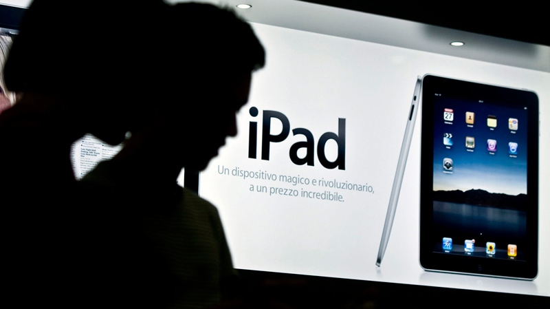 Customers are silhouetted at the launch of the new iPad tablet computer at an Apple store. (AP / Angelo Carconi)