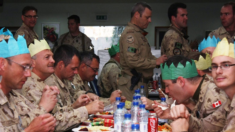 Canadian soldiers chow down on their special Christmas Day dinner while others wait for their grub at Kandahar Airfield on Friday, Dec. 25, 2009. (Colin Perkel / THE CANADIAN PRESS)