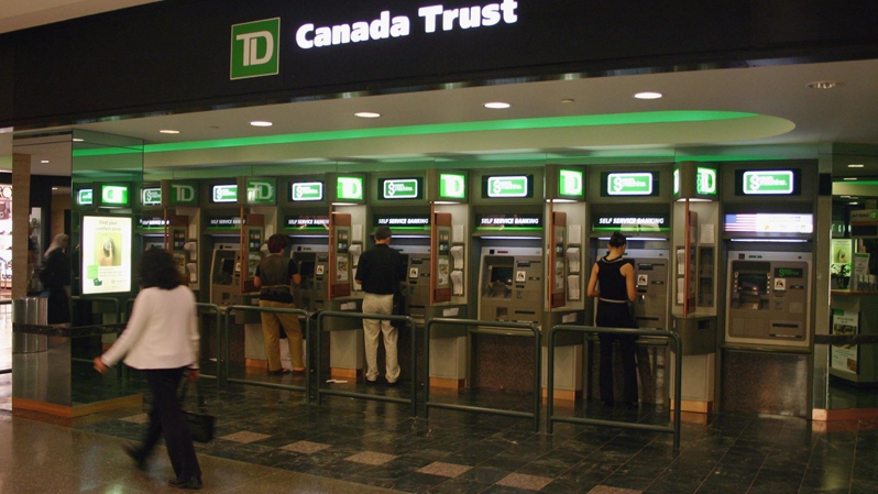 Customers use bank machines at the TD bank in Toronto. (THE CANADIAN PRESS)