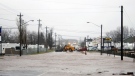 High water reaches Main St. as a plow blocks traffic in Shediac N.B. on Tuesday Dec. 21, 2010. (Peter Langis / THE CANADIAN PRESS)
