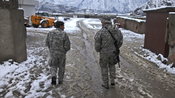 A U.S. Army soldier, right, walks with an Afghan translator the morning after a night of snow, at Forward Operating Base Blessing, in the Pech Valley, Kunar province, northeastern Afghanistan, Friday Jan. 29, 2010. (AP Photo/Brennan Linsley)