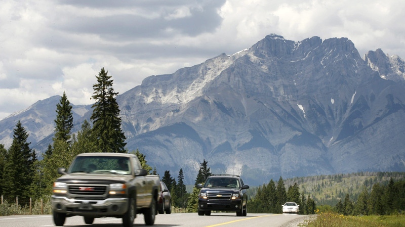 Vehicles drive along the Trans-Canada Highway through Banff National Park with Mt. Cascade in the background. (Jeff McIntosh / THE CANADIAN PRESS)