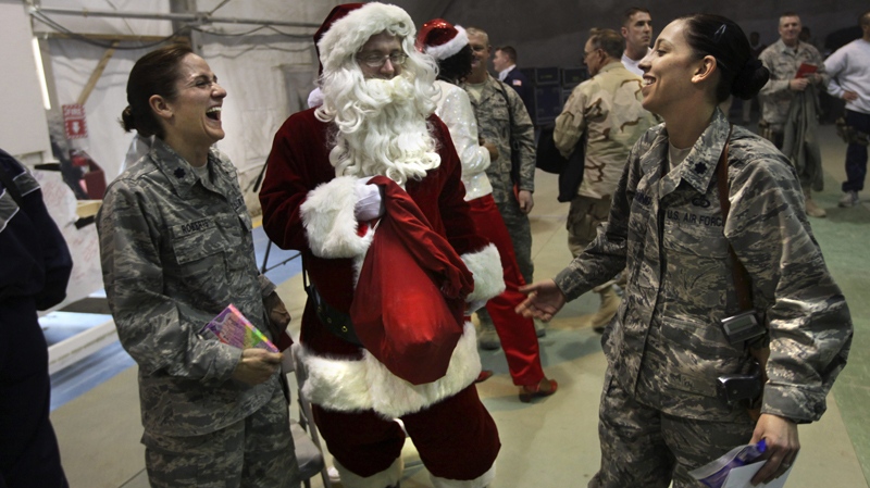 A U.S. soldier dressed up as Santa Claus distributes gifts to other soldiers during Christmas celebrations at Bagram air base, north of Kabul, Afghanistan, Saturday, Dec. 25, 2010. (AP / Altaf Qadri)