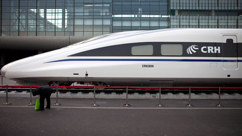 A man bows down to check a CRH380A high speed Chinese passenger train, the model that hit a record speed of 486 kph during a test run of a yet-to-be opened link between Beijing and Shanghai, outside the venue of 7th World Congress on High Speed Rail in Beijing, China, Tuesday, Dec. 7, 2010. (AP / Alexander F. Yuan)
