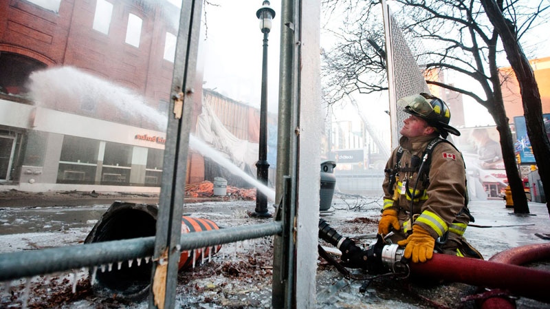 A member of the Toronto Fire Department battles a blaze at Yonge Street and Gould Street, just a block away from Yonge and Dundas Square, in Toronto Monday, Jan. 3, 2011.  (Darren Calabrese / THE CANADIAN PRESS)