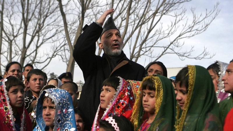 Afghan President Hamid Karzai center, looks on as he stands with Afghan orphans during a visit to President palace in Kabul, Afghanistan, Wednesday, Jan 5, 2011. (AP Photo/Ahmad Massoud/Pool)