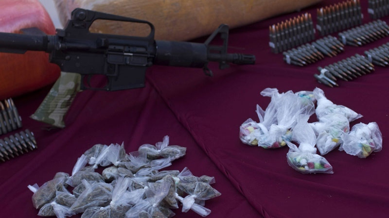 Weapons and drugs are displayed during a presentation for the media in Tijuana, Mexico, Wednesday, Jan. 5, 2011. (AP Photo/Guillermo Arias)