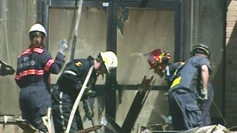 Workers clean up following a devastating blaze at the Campus Court Plaza in Waterloo on April 22, 2010.