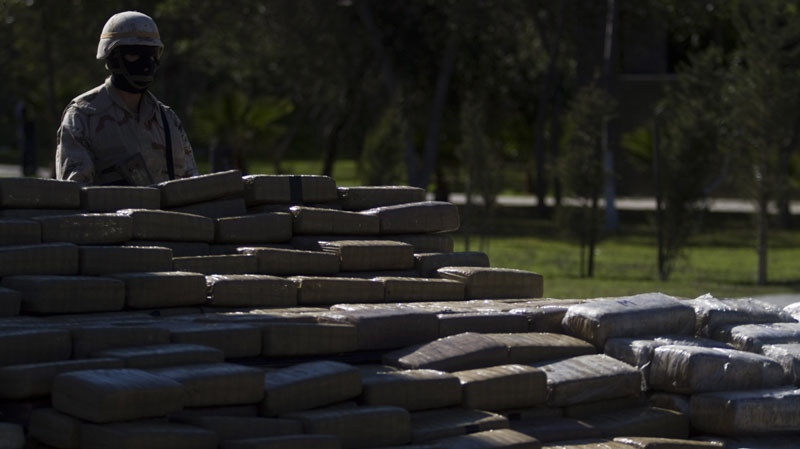 A soldiers stands next to seized packages of marijuana as they are displayed to the media in Tijuana, Mexico, Thursday Dec. 30, 2010. (AP Photo/Guillermo Arias)