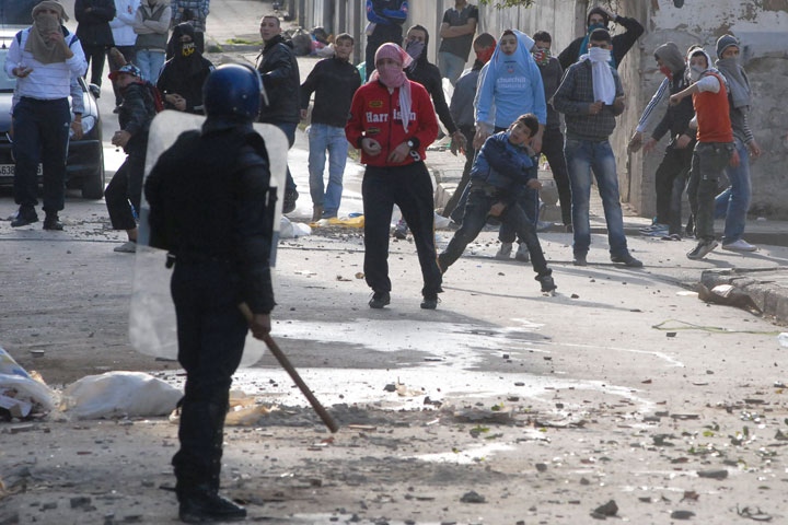 Youth face police forces in the Belcourt district of Algiers, Friday Jan. 7, 2011. (AP Photo)