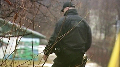 A Waterloo Regional Police Service officer searches the area where John Ferreira was attacked on the Iron Horse Trail in Kitchener, Tuesday, Jan. 4, 2011.