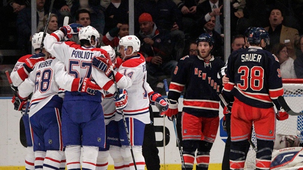 Montreal Canadiens' Tomas Plekanec (14), Benoit Pouliot (57), and Yannick Weber (68) celebrate a goal by Jaroslav Spacek during the second period of an NHL hockey game as New York Rangers' Brandon Prust (8) and Mike Sauer (38) look on, Tuesday, Jan. 11, 2011, in New York. The Canadiens won 2-1. (AP Photo/Frank Franklin II)