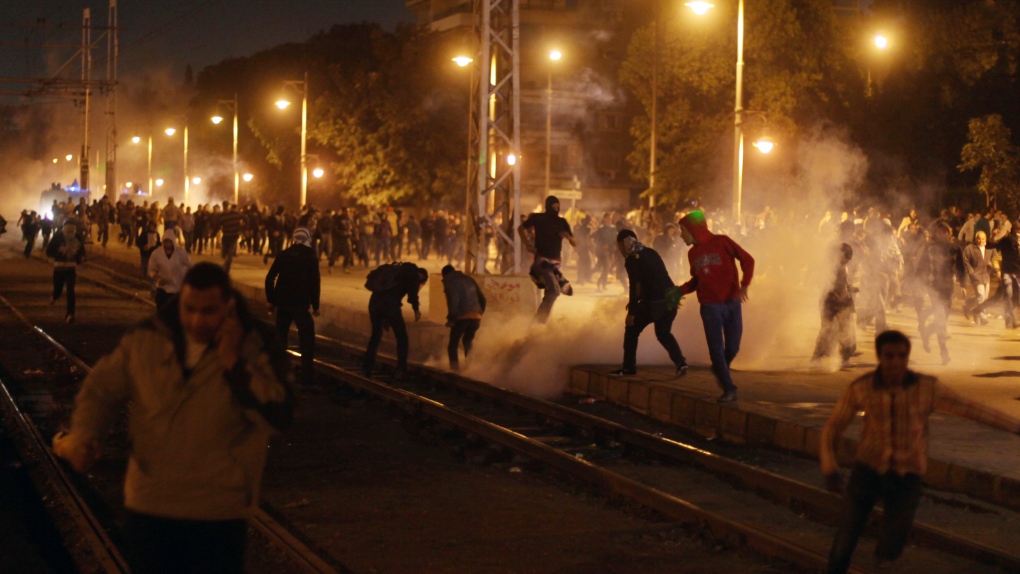 Egyptian protesters run from tear gas