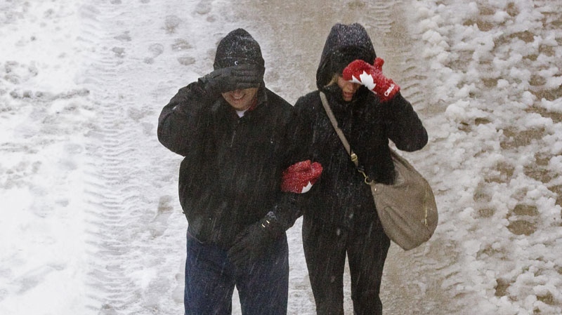 Pedestrians shield their faces as a winter storm starts in Halifax on Wednesday, Jan. 12, 2011. (THE CANADIAN PRESS/Andrew Vaughan)