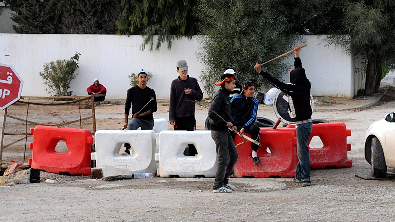 Youths guard a check point in Tunis, Monday Jan.17, 2011. (AP / Hassene Dridi)