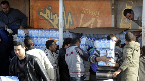 A trucker, top right, sells milk on a street in Tunis, Monday Jan. 17, 2011. (AP Photo/Salah Habibi)