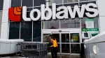 A Loblaws employee brings in shopping carts in Toronto on Wednesday, Feb. 18, 2009. (Nathan Denette / THE CANADIAN PRESS)