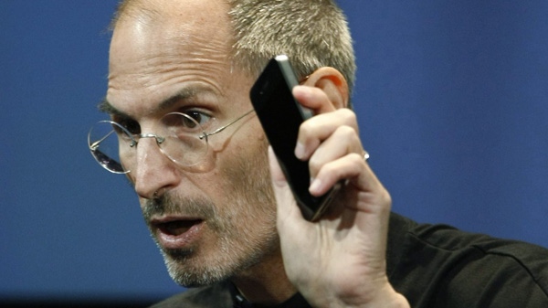 In a July 16, 2010 file photo, Apple CEO Steve Jobs holds up an iPhone 4 as he talks about the product at Apple headquarters in Cupertino, Calif. (AP Photo/Paul Sakuma, File)