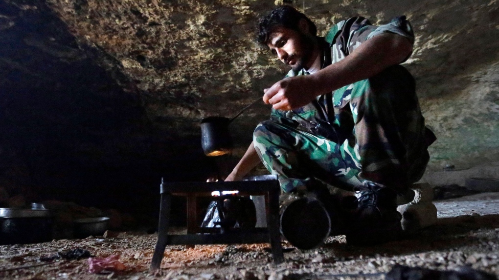 Free Syrian Army fighter makes coffee in cave