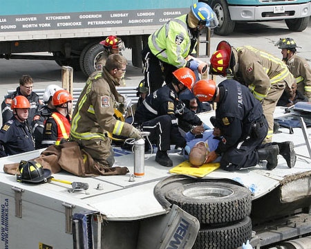 A guard is pulled from the wreckage of a Brinks truck that rolled off a Toronto highway ramp on Sunday. (John Hanley / Special to CTV.ca)
