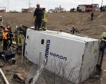 Rescuers survey the scene after an armoured truck rolled off the higwhay on Sunday, trapping three people inside. (John Hanley / Special to CTV.ca)