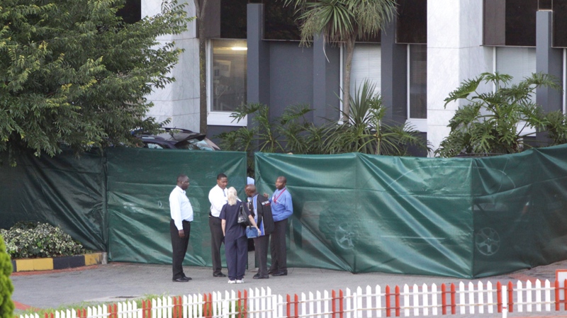 Unidentified people enter a cordoned off area outside the Milpark Hospital where former South African President Nelson Mandela is said to be undergoing routine tests Wednesday Jan. 26, 2011. (AP / Denis Farrell)