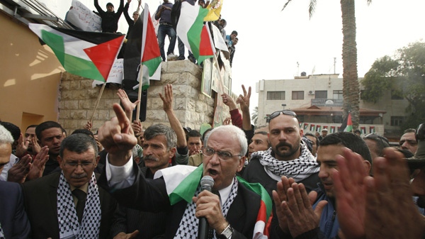 Senior Palestinian negotiator Saeb Erekat, centre, surrounded by Fatah supporters speaks during a rally in the West Bank town of Jericho, Tuesday, Jan. 25, 2011. (AP Photo/Muammar Awad)