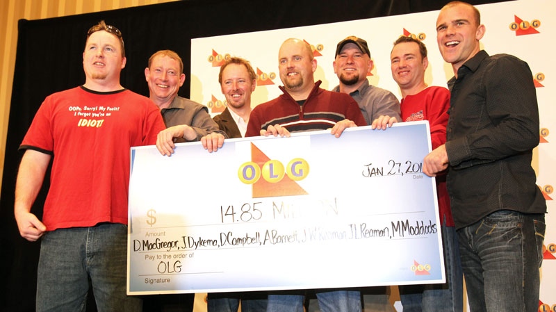 Super 7 Lottery winners (left to right) Joseph Reaman, James Reaman, Michael Maddocks, Daniel MacGregor, Jason Dykema, Daniel Campbell and Adam Barnett hold the winning cheque for 14.85 million dollars during a news conference in Toronto on Thursday January 27, 2011. (Frank Gunn / THE CANADIAN PRESS)