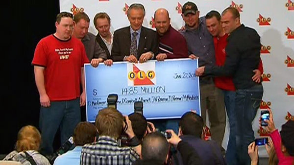 Paul Godfrey, chairman of the board of the Ontario Lottery and Gaming Corporation, holds up a cheque with the winners of a multi-million dollar Super 7 jackpot at a news conference in Toronto, Thursday, Jan. 27, 2011.