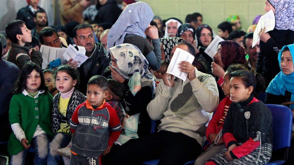 Syrian families wait to register at the UNHCR