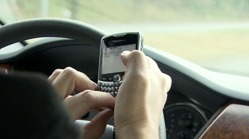 A driver is seen using a cell phone while driving, an illegal offense in most provinces.
