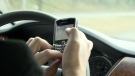 A driver is seen using a cell phone while driving, an illegal offense in most provinces, in this undated photo.