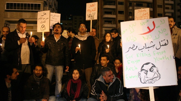 In this Jan. 29, 2011 file photo, Syrian protesters hold candles during a vigil for those killed in the Egyptian demonstrations, near the Egyptian embassy in Damascus, Syria. The Arabic placards read:" Yes for freedom", background, and "No for killing the Egyptian youth", foreground. (AP Photo/Muzaffar Salman)