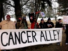 Demonstrators carry a sign reading 'Cancer Alley' during a 'Toxic Tour' demonstration in Sarnia, Ont. on Friday, March 15, 2013. (Talia Ricci / CTV London)