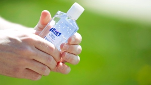 A news reporter holds a bottle of hand sanitizer at a news conference in this 2009 file photo. (Troy Fleece/ THE CANADIAN PRESS)