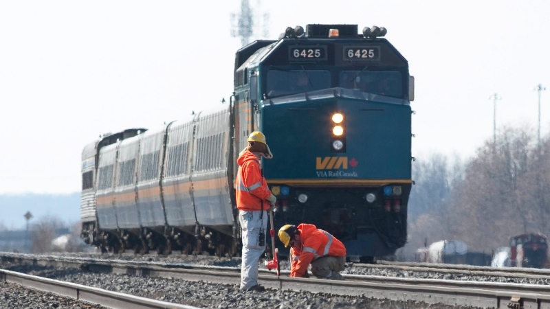 Crews work on the tracks ahead of a VIA Rail passenger train in this February 2012 file photo. (Pawel Dwulit / THE CANADIAN PRESS)