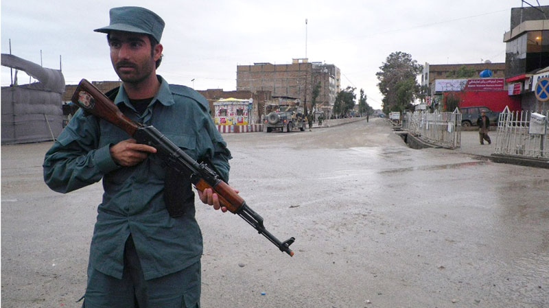 An Afghan police man stands guard on the road leading to the Kandahar police headquarters in Kandahar south of Kabul, Afghanistan, Saturday, Feb, 12, 2011. (AP / Allauddin Khan)