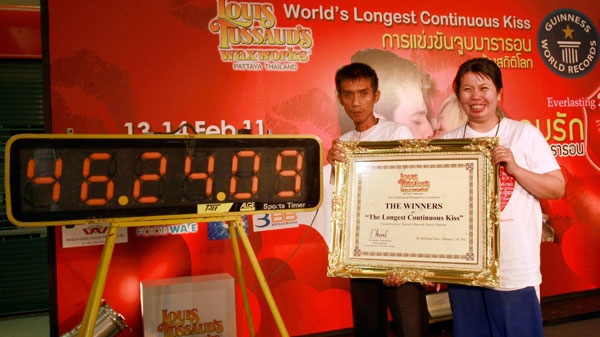 Laksana Tiranarat, right, and husband Ekkachai pose with a certificate after winning the World's Longest Continuous Kiss contest and set a new record at 46.24.09 hours in Pattaya, southeastern Thailand Tuesday, Feb. 15, 2011. (AP Photo / Apichart Weerawong)