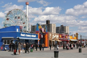 Visitors to New York's Coney Island walk on the boardwalk past the open businesses, Saturday, March 30, 2013. (AP / Mary Altaffer)
