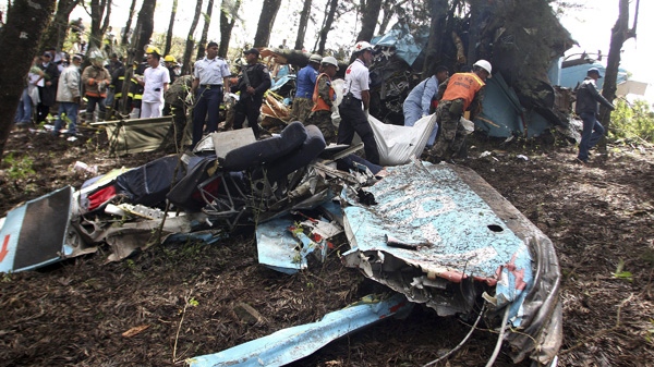 Rescue workers remove bodies from the wreckage of a small commercial airplane after it crashed near the town of Las Mesitas on the outskirts of the capital city of Tegucigalpa, Honduras Monday Feb. 14, 2011. (AP Photo/Fernando Antonio)