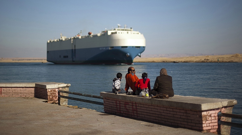 A cargo ship transits the Suez Canal en route from the Mediterranean Sea to the Gulf of Suez at the city of Suez, Egypt, Wednesday, Feb. 2, 2011. (AP / Emilio Morenatti)